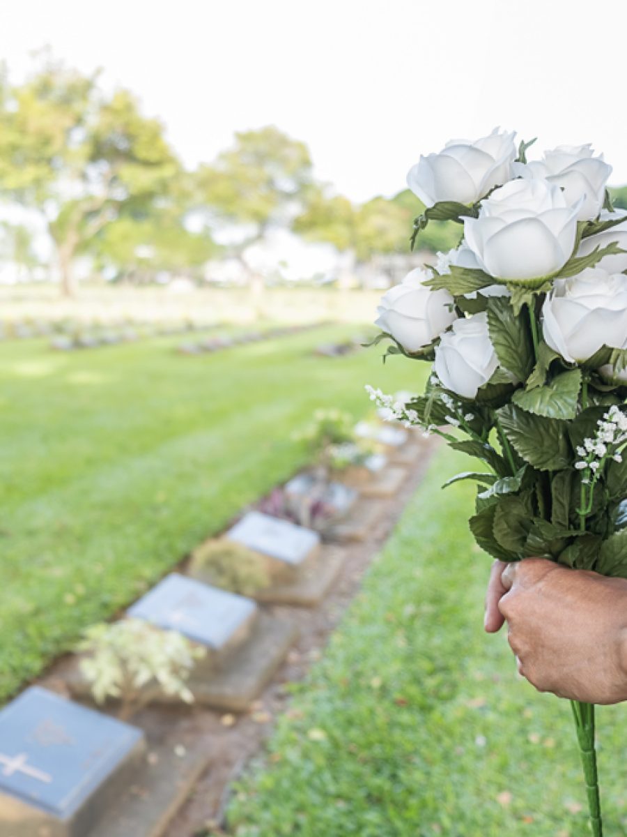 Mourning,Young,Woman,Holding,White,Flowers,At,Her,Family,Grave Mourning,Young,Woman,Holding,White,Flowers,At,Her,Family,Grave